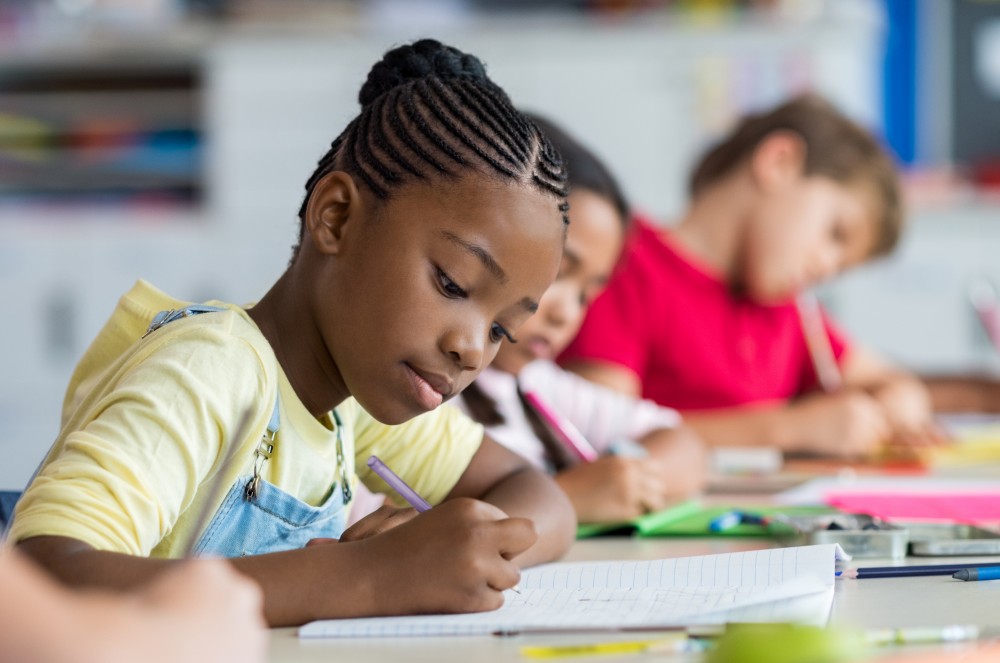 young girl taking notes in class